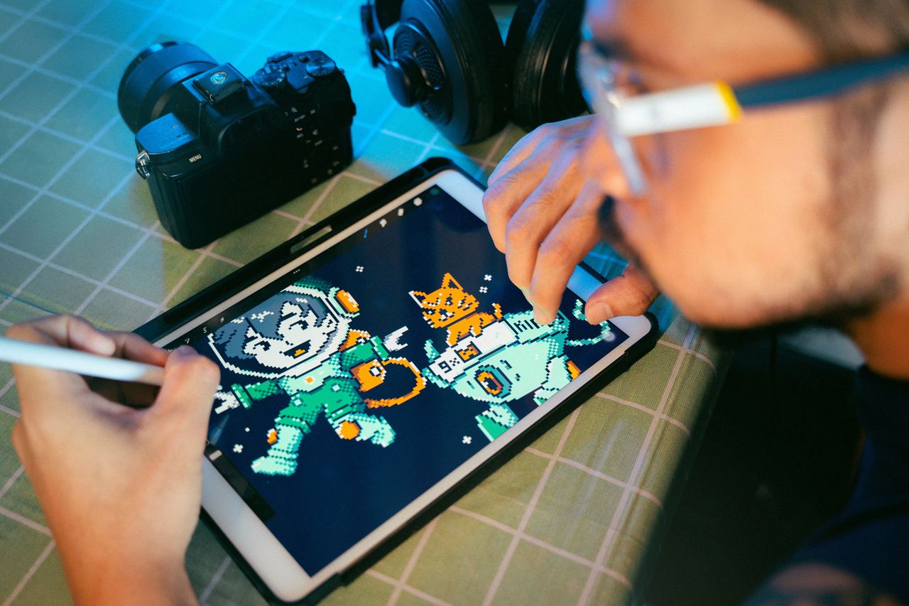 The Art of Drawing Readers In: Your attractive post title goes here Person drawing digital art on a tablet using a stylus next to camera and headphones.